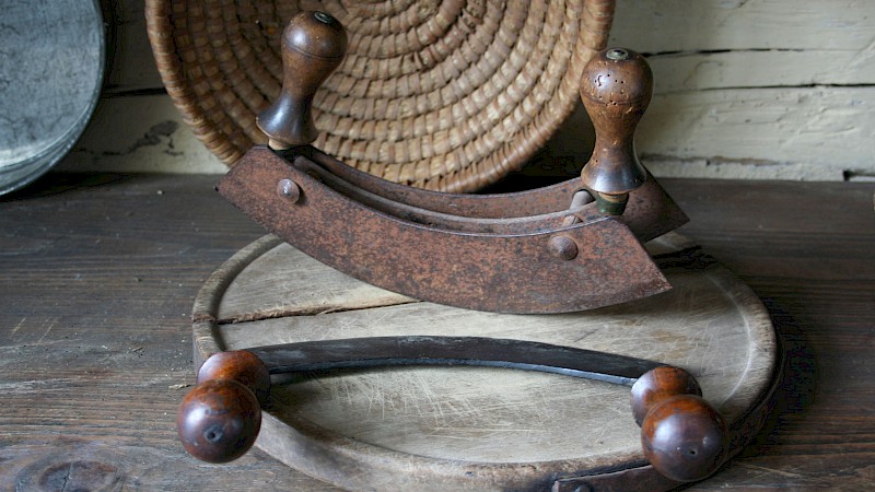 Zwei historische Kräuterwiegen auf einem Holzbrett