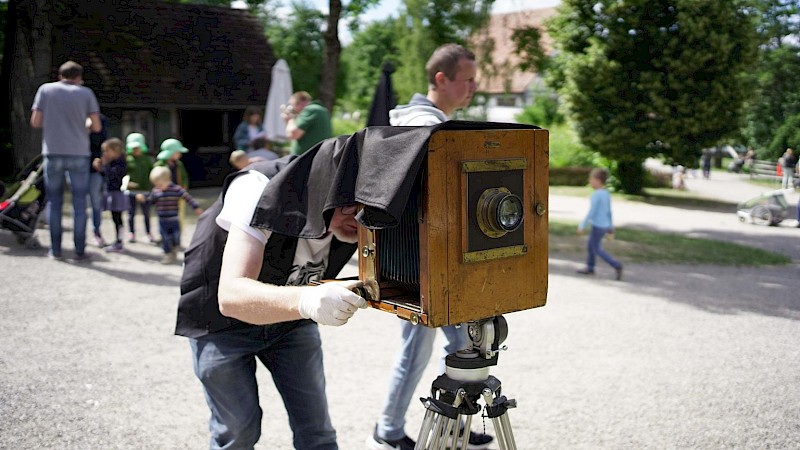 Eine Person bedient eine historische Kamera