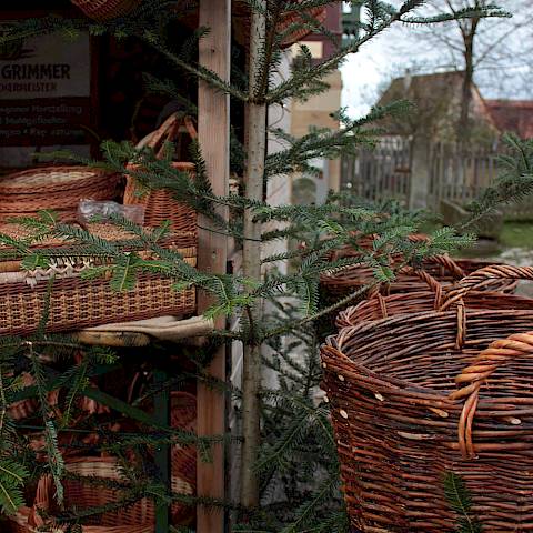 Geflochtene Körbe zwischen Tannenzweigen an einem Verkausfsstand
